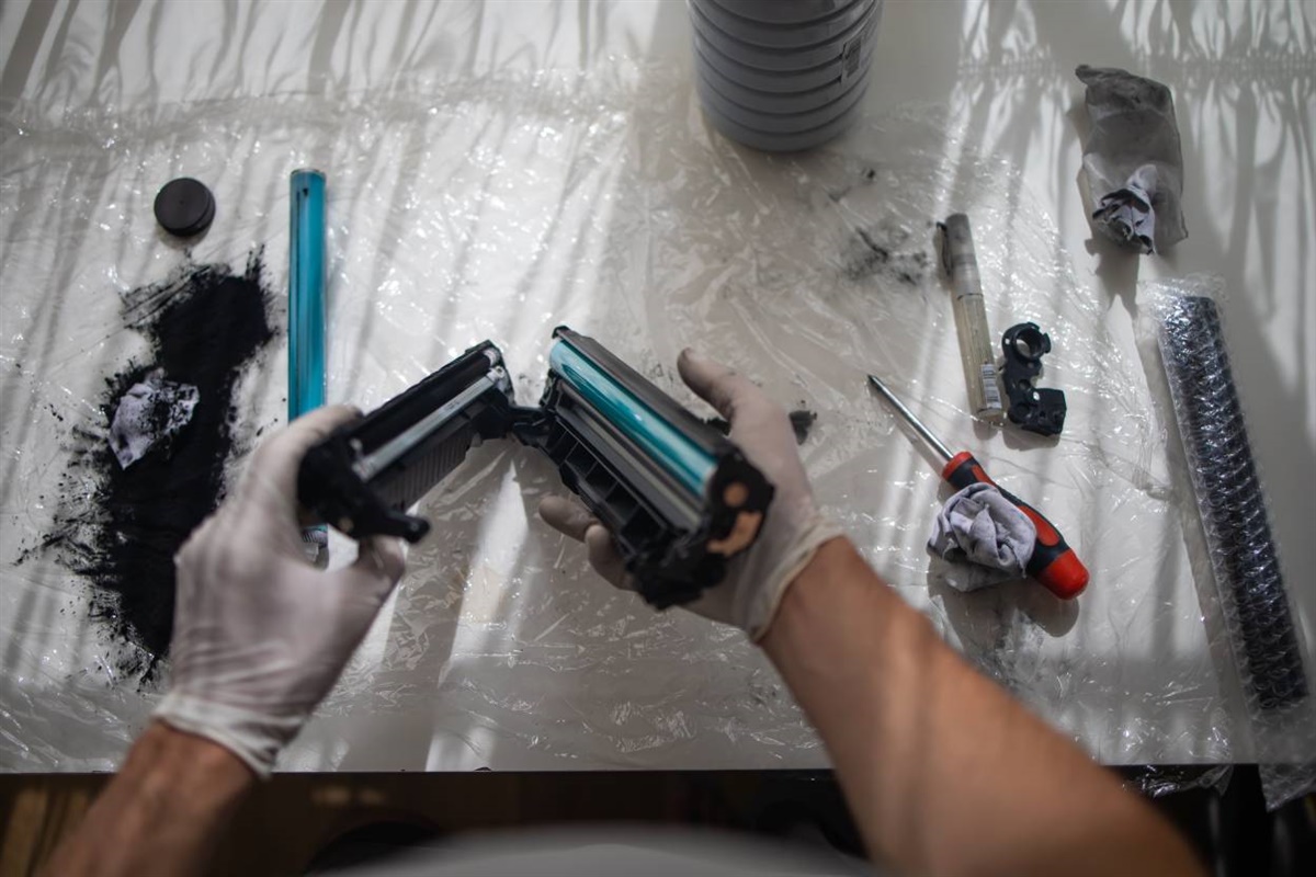 Geöffnete Tonerkartusche mit ausgetretenem Tonerpulver auf einer abgedeckten Arbeitsfläche