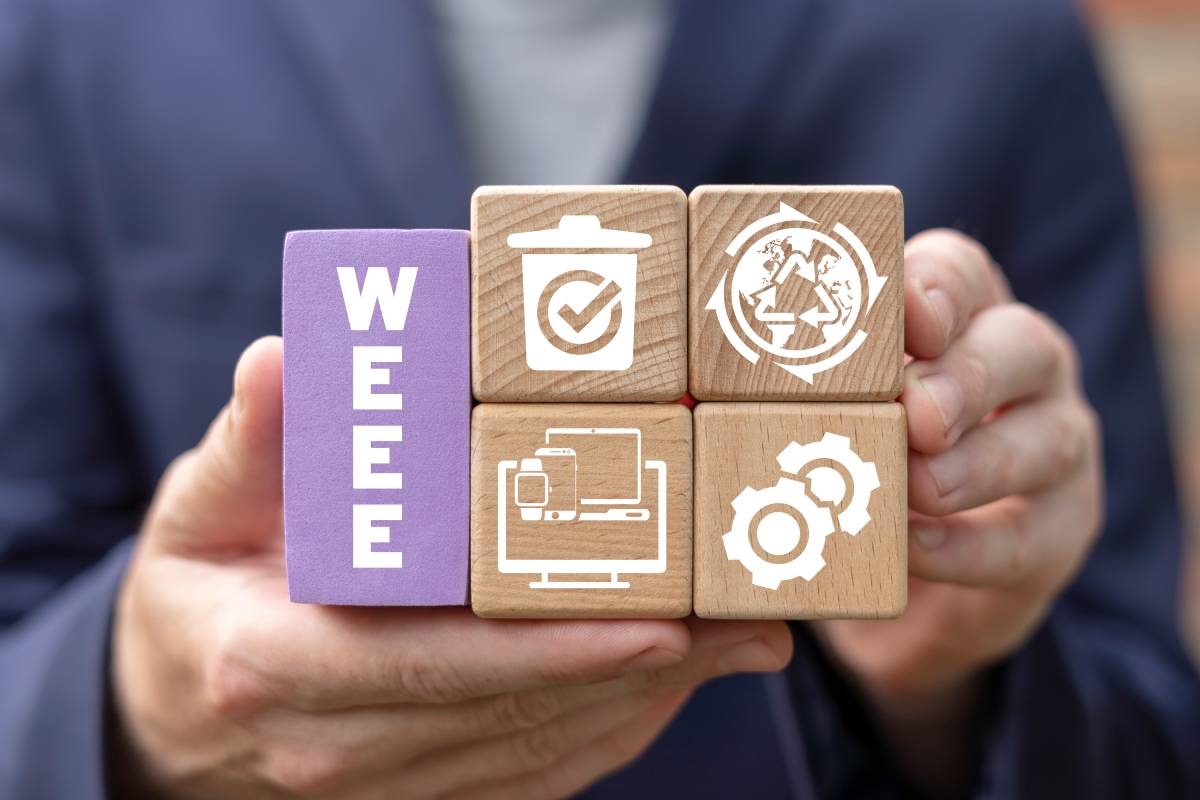 Holzwürfel mit der Aufschrift WEEE und Symbolen für Elektrogeräte, Mülltonne und Recycling